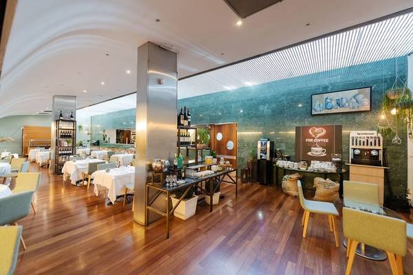Frühstücksraum des Atenea Barcelona Aparthotel mit Holzboden und grünen Wänden.