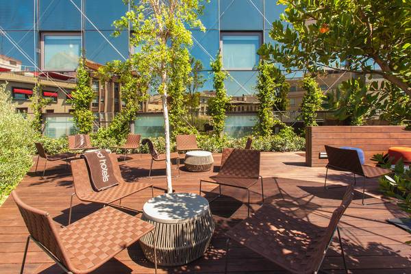 Terrasse im Hotel Ocean Drive Barcelona mit braunen Stühlen und einem Tisch