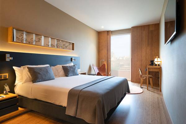 Schlafzimmer im Ocean Drive Barcelona Hotel mit Doppelbett, Nachttischen und modernem Design.