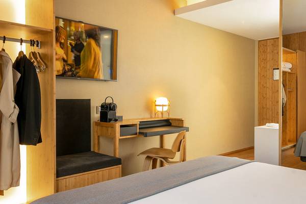 Innenansicht eines Hotelzimmers im Ocean Drive Barcelona mit Schreibtisch, Lampe und Fernseher.