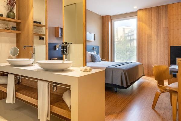 Innenansicht eines Zimmers im Ocean Drive Barcelona Hotel mit zwei Waschbecken und einem Bett.