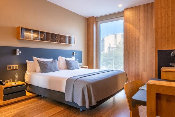 Hotelzimmer von Ocean Drive Barcelona mit einem großen Bett, Holzwänden und einem Schreibtisch.