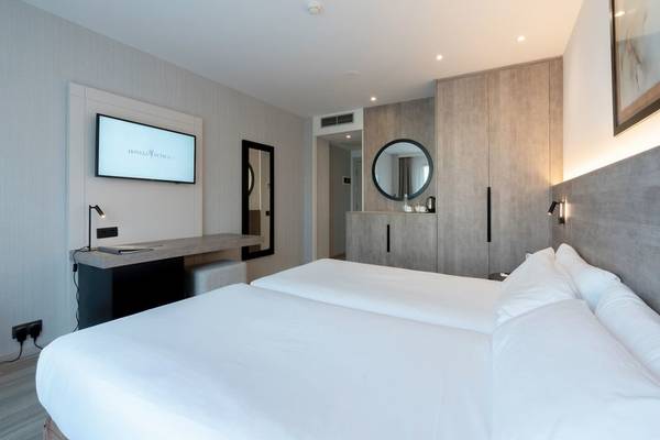 Ein Schlafzimmer im Attica 21 Barcelona Mar Hotel mit zwei Betten, einem Fernseher und einem Schreibtisch.