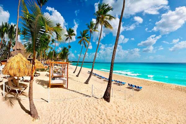 Strand des Catalonia Bayahibe Hotels mit blauem Meer und Sonnenliegen