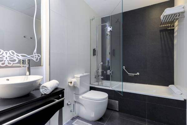 Das Badezimmer im Ciutadella Barcelona Hotel mit Badewanne, Dusche und Waschbecken.