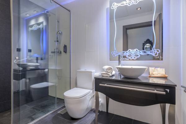 Badezimmer im Ciutadella Barcelona Hotel mit Duschbereich, Toilette und Waschtisch.