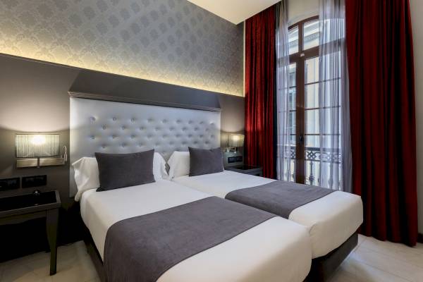 Doppelbett-Zimmer im Ciutadella Barcelona Hotel mit moderner Einrichtung und Aussicht.
