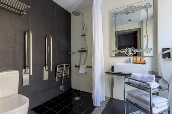 Barrierefreies Badezimmer im Ciutadella Barcelona Hotel mit behindertengerechter Dusche und Toilette.