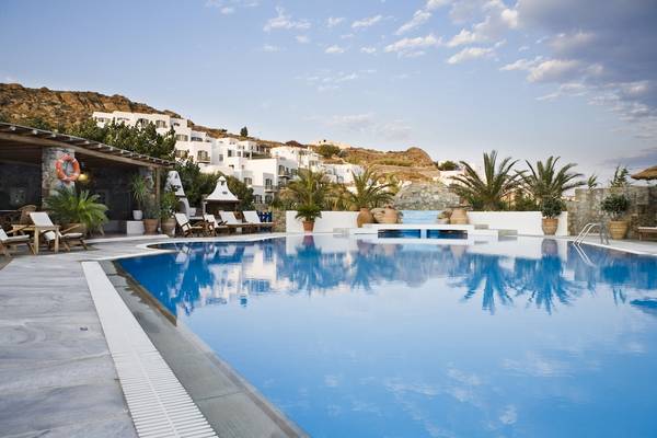 Außenbereich des Kamari Hotels mit Swimmingpool, Sonnenliegen und Palmen