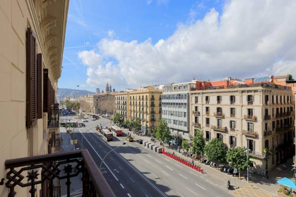 Aussicht von der Ciutadella Barcelona Hotel auf eine belebte Straße mit Bussen und Gebäuden.