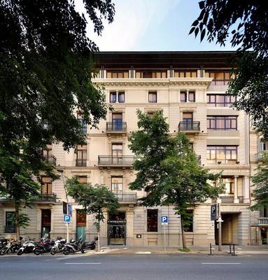 Frontansicht des HCC St. Moritz Hotels mit mehreren Motorrädern davor und Bäumen