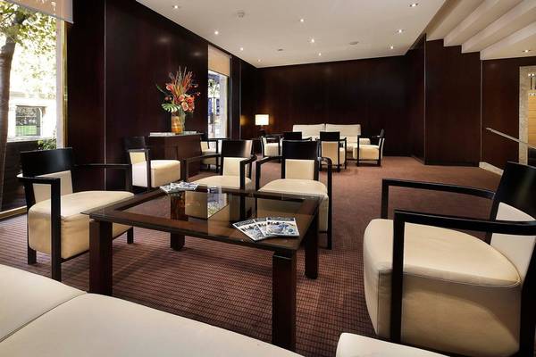 Lobby des HCC St. Moritz Hotels mit modernen Möbeln und einer Blumenvase.