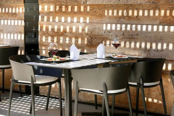 Tisch im Restaurant HCC St. Moritz mit Speisen und Weingläsern auf einer Marmorwand im Hintergrund.