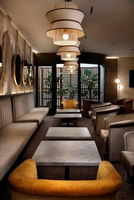 Der Loungebereich des HCC St. Moritz Hotels mit Möbeln, Tischen und dekorativen Lampen.