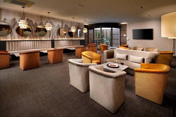Loungebereich des HCC St. Moritz Hotels mit Möbeln, Sofas und einer Fernsehwand.