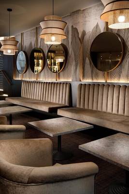 Loungebereich des HCC St. Moritz Hotels mit Sofas, Tischen und dekorativen Spiegeln