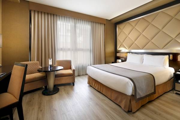 Hotelzimmer im HCC St. Moritz mit Bett, Stühlen und Tisch.