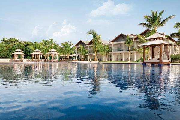 Außenpool des Hilton La Romana Hotels mit Sonnenliegen und Palmen