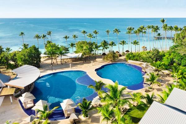 Luftaufnahme des Hilton La Romana Resorts mit zwei Swimmingpools, Palmen und Blick aufs Meer.