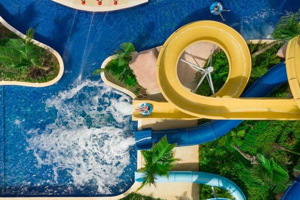 Draufsicht auf Wasserrutschen im Hilton La Romana Hotel mit Gästen in Schwimmreifen