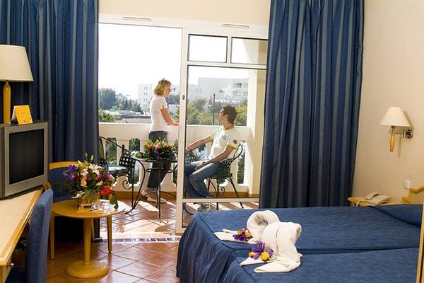 Zimmer mit Balkon im Medina Belisaire & Thalasso Hotel, mit Blick auf eine Frau, die auf den Balkon schaut und einen Mann, der im Stuhl sitzt.