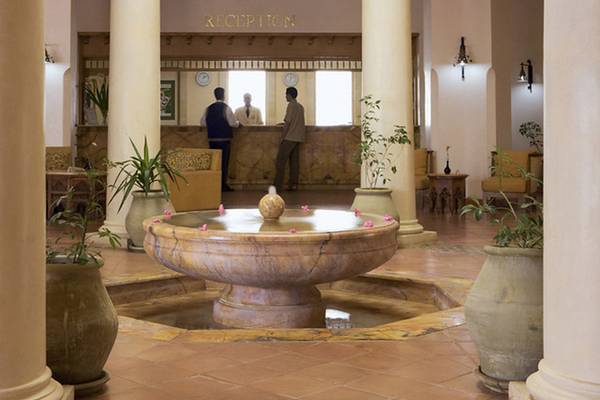Empfangsbereich des Medina Belisaire & Thalasso Hotels mit einer Brunnenanlage und hohen Säulen.