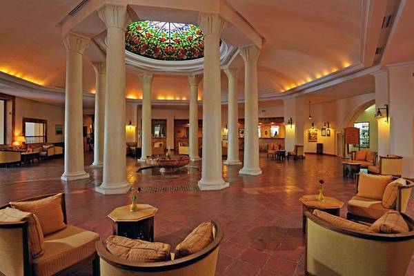 Innenansicht des Empfangsbereichs des Medina Belisaire & Thalasso Hotels mit Säulen und farbigem Glasdach