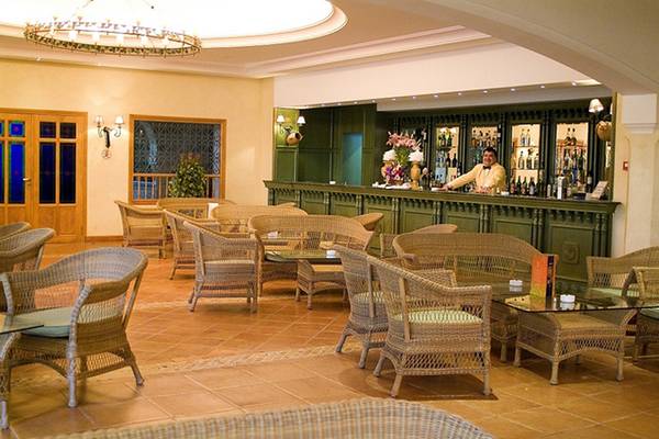 Barbereich des Medina Belisaire & Thalasso Hotels mit grünen Wänden und Holzmöbeln.
