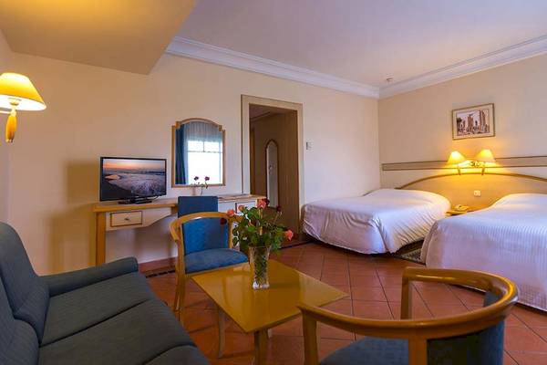 Zimmer im Medina Belisaire & Thalasso Hotel mit zwei Betten, Fernseher, Tisch und Sofa.