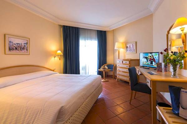 Hotelzimmer im Medina Belisaire & Thalasso mit Bett, Schreibtisch und Fernseher.