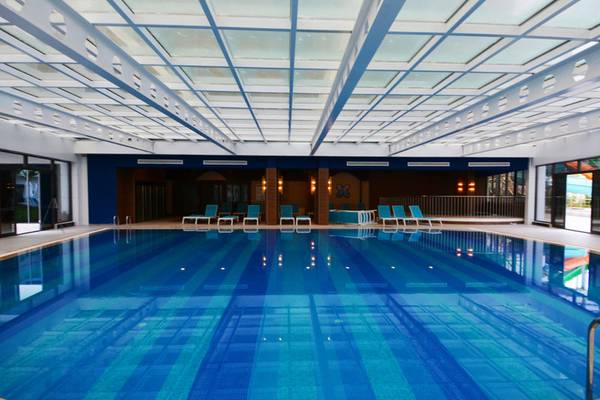Innenpool des Diamond Premium Hotel & Spa mit blauen Wänden und Liegestühlen