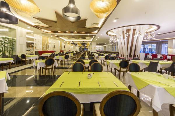 Restaurant im Diamond Premium Hotel & Spa mit gedeckten Tischen und hängenden Lampen.