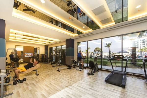 Fitnessstudio im Diamond Premium Hotel & Spa mit gut ausgestatteten Geräten und großer Fensterfront.