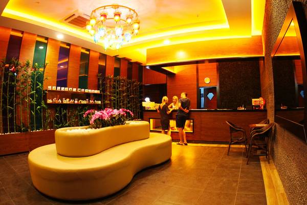Lobby des Diamond Premium Hotel & Spa mit Rezeption, Sofa und Blumendekor.