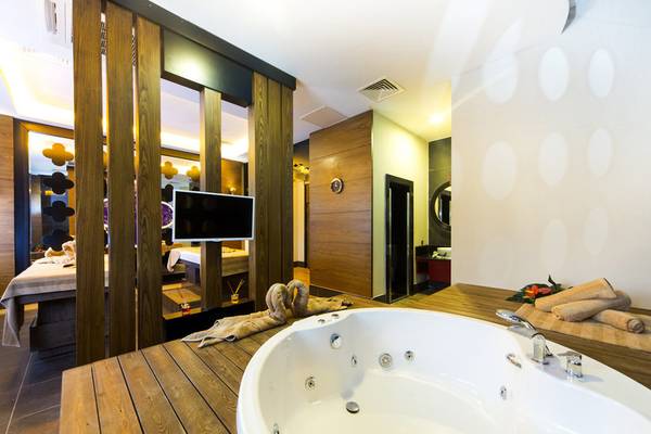 Badezimmer im Diamond Premium Hotel & Spa mit Whirlpool und Fernseher.