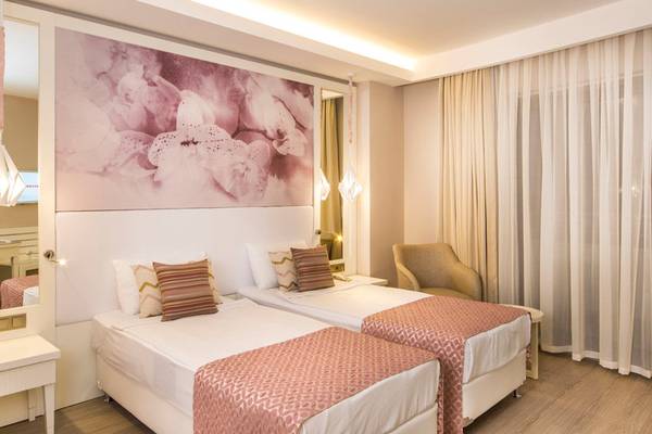 Doppelzimmer im Diamond Premium Hotel & Spa mit zwei Betten, Dekor und Möbeln.