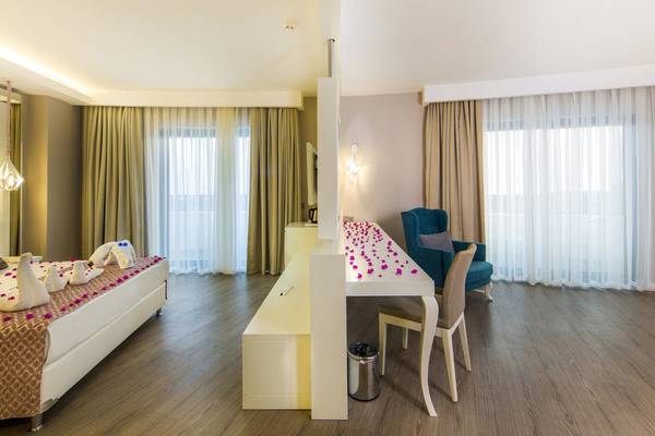 Innenansicht des Schlafzimmers im Diamond Premium Hotel & Spa mit Doppelbett, Schreibtisch und Sessel.