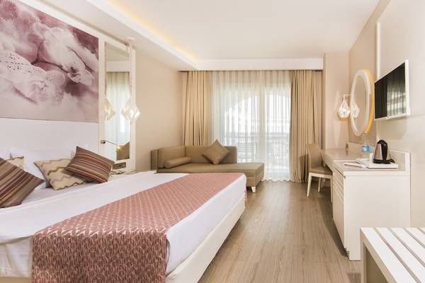 Schlafzimmer im Diamond Premium Hotel & Spa mit Doppelbett, Sofa, Schreibtisch und Fernseher.