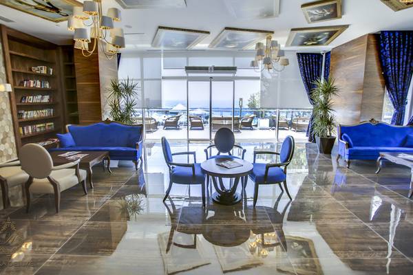 Lobby des Azura Deluxe Resort & Spa mit blauen Möbeln und Aussicht auf den Ozean.