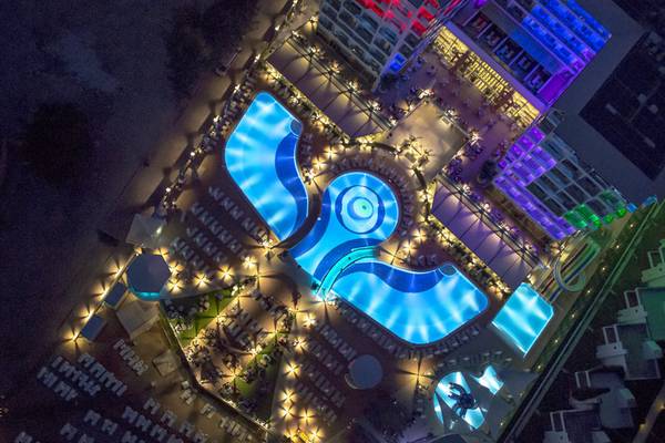 Azura Deluxe Resort & Spa Außenansicht bei Nacht mit beleuchtetem Pool und Hotel
