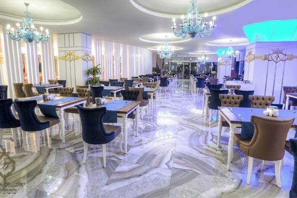Innenbereich eines Restaurants im Azura Deluxe Resort & Spa mit blauen Stühlen und Tischen.