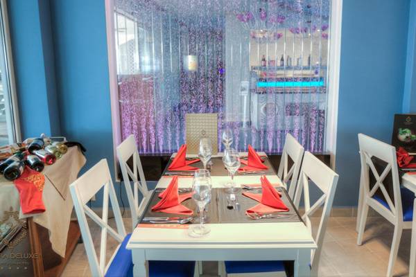 Esstisch im Restaurant des Azura Deluxe Resort & Spa mit roter Tischdecke und Geschirr.