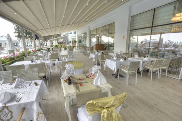 Innenbereich des Azura Deluxe Resort & Spa Restaurants mit gedeckten Tischen und Stühlen.