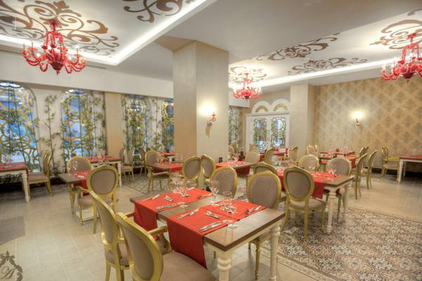 Innenansicht des Restaurants im Azura Deluxe Resort & Spa mit eleganten Tischeinstellungen und dekorativen Kronleuchtern.