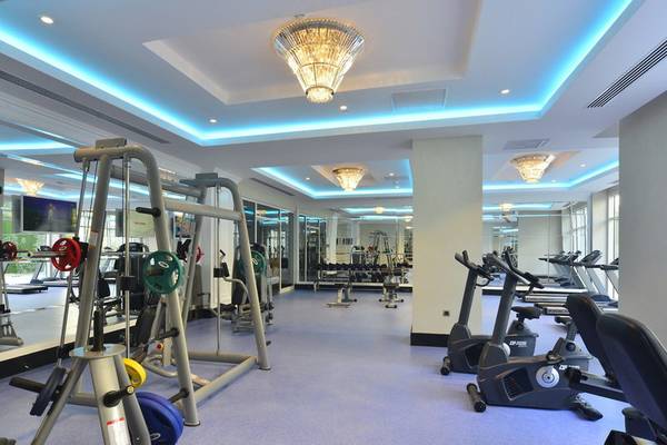 Fitnesscenter im Azura Deluxe Resort & Spa mit verschiedenen Trainingsgeräten und Spiegeln.