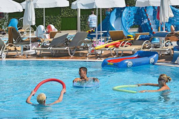 Gäste im Azura Deluxe Resort & Spa spielen im Swimmingpool mit Schwimmringen.