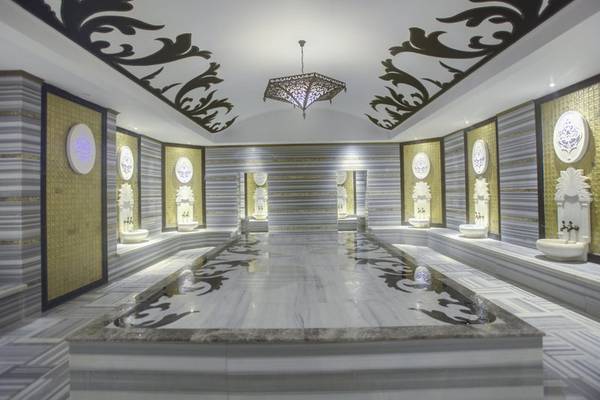 Innenansicht der Sauna im Azura Deluxe Resort & Spa mit Marmorboden und goldenen Akzenten.