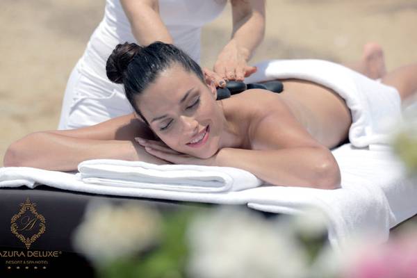 Frau am Strand genießt eine Massage im Azura Deluxe Resort & Spa Hotel.