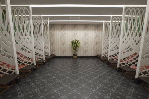 Innenbereich des Azura Deluxe Resort & Spa mit weißen geometrischen Mustern und roten Kissen.