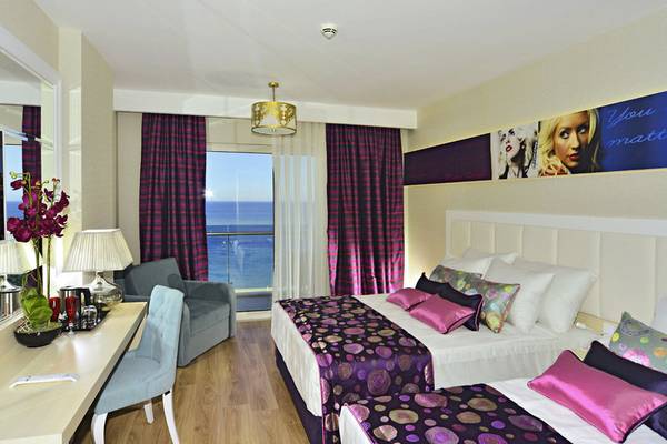 Doppelzimmer im Azura Deluxe Resort & Spa mit Meerblick, zwei Betten und Balkon.